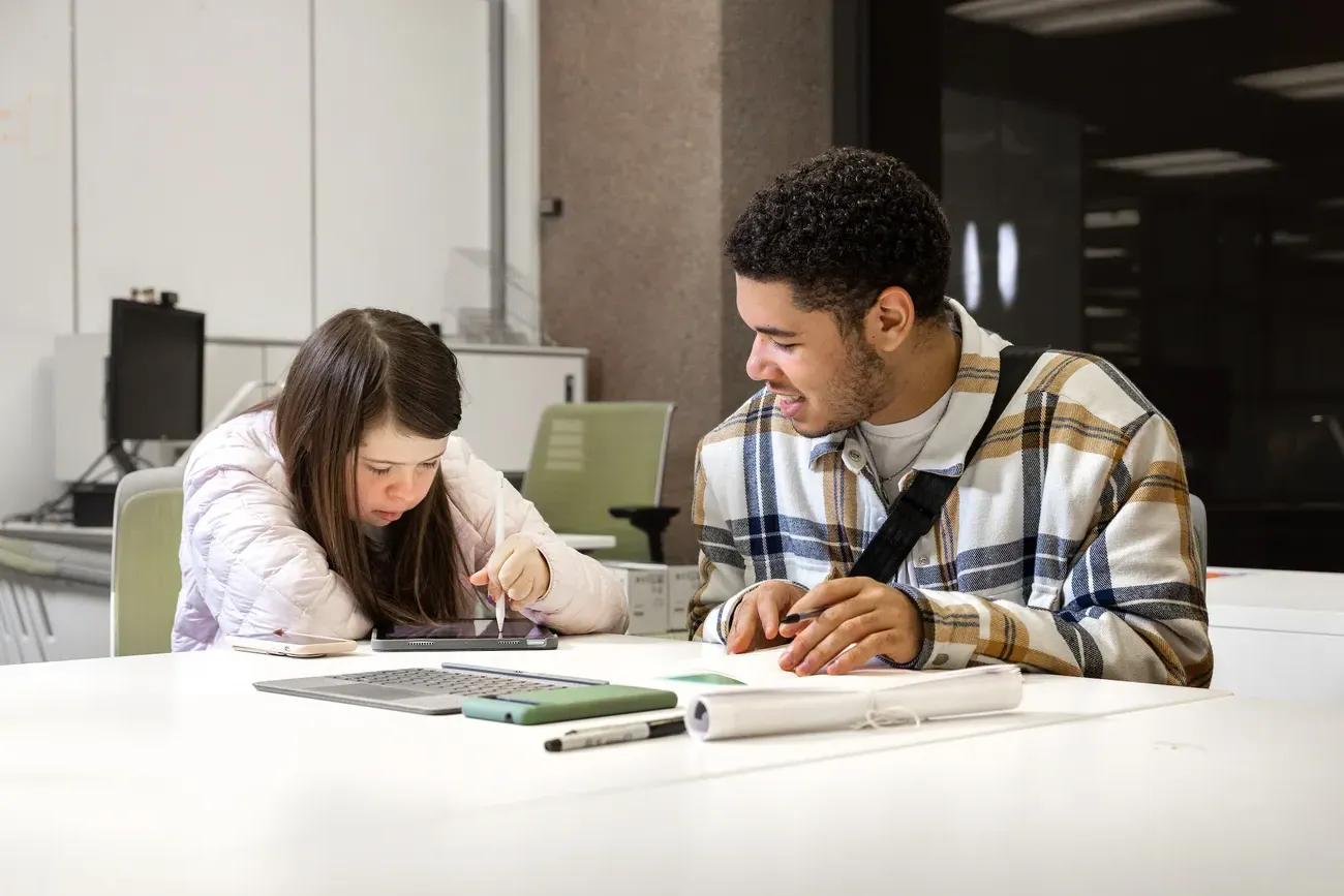 Two people working together at a table.